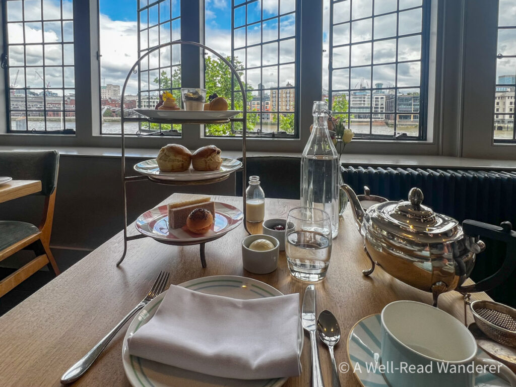 afternoon tea tray and pot on a table overlooking london river thames