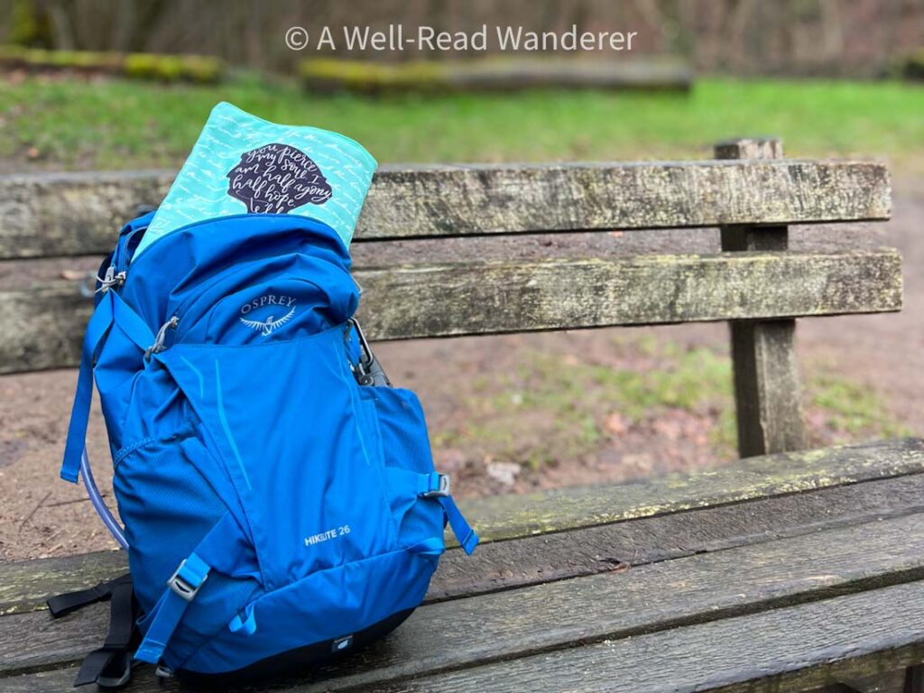 book sleeve best travel gear, book sleeve in a blue hiking pack on a wooden bench