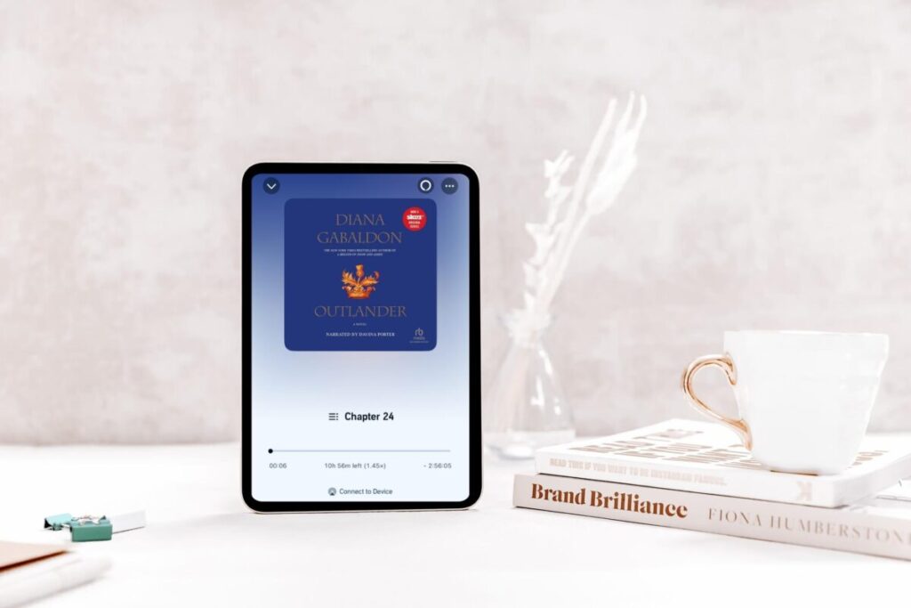 outlander audiobook on a tablet next to tea, narrated by davina porter