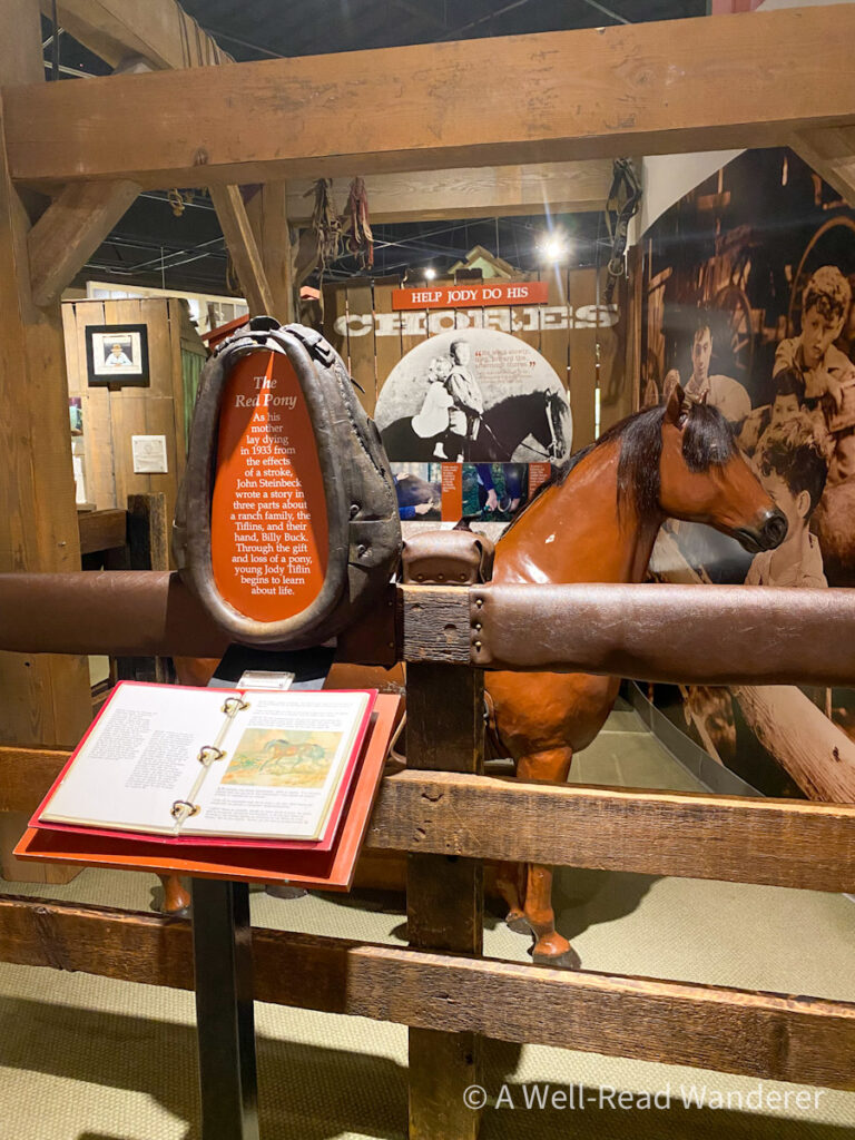 statue of red pony with informational plaques around it