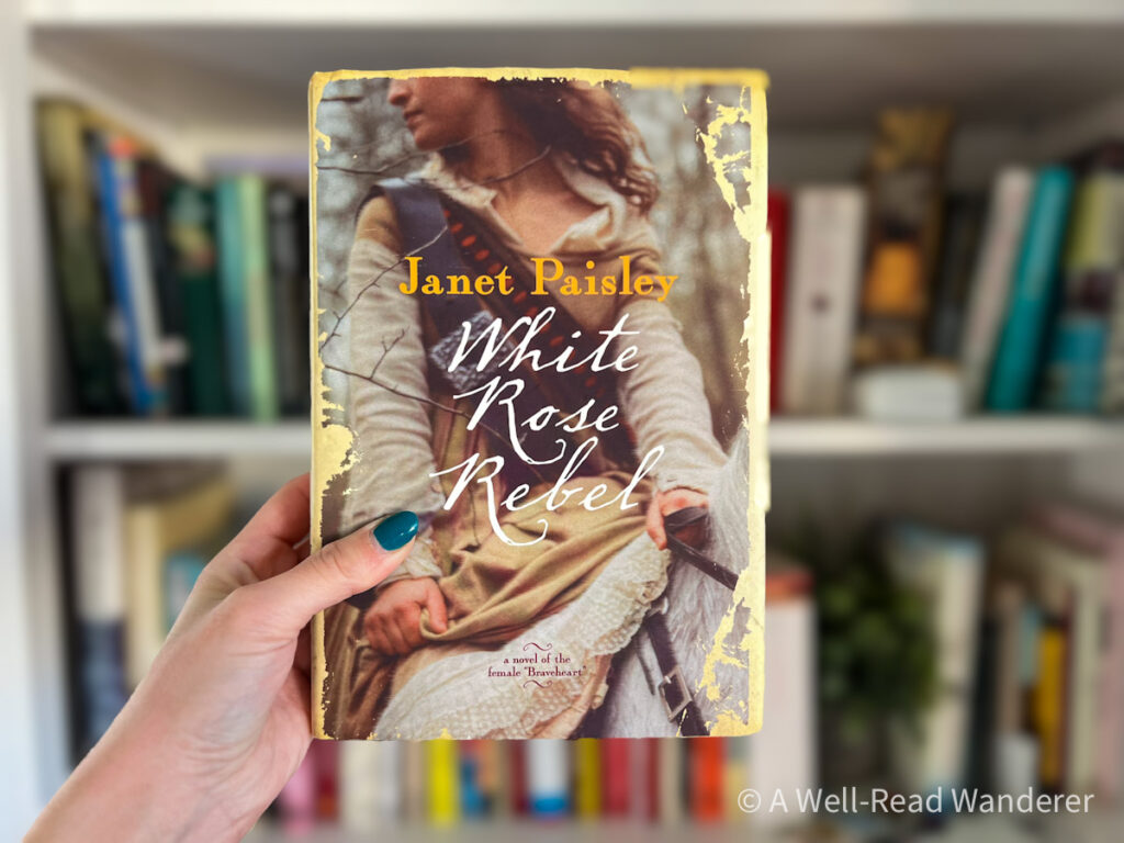 white rose rebel, scottish historical fiction romance novel, held in front of a bookshelf