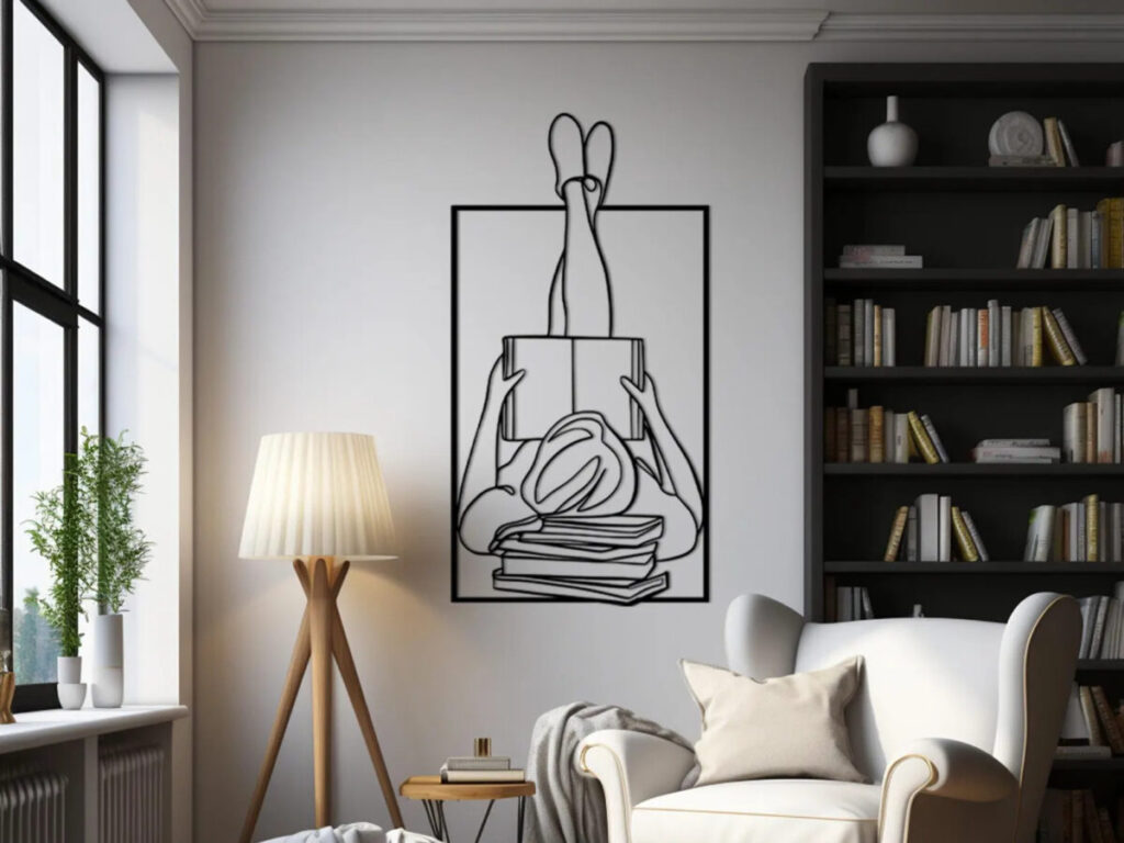line art wall hanging of a person reading a book with their feet up the wall