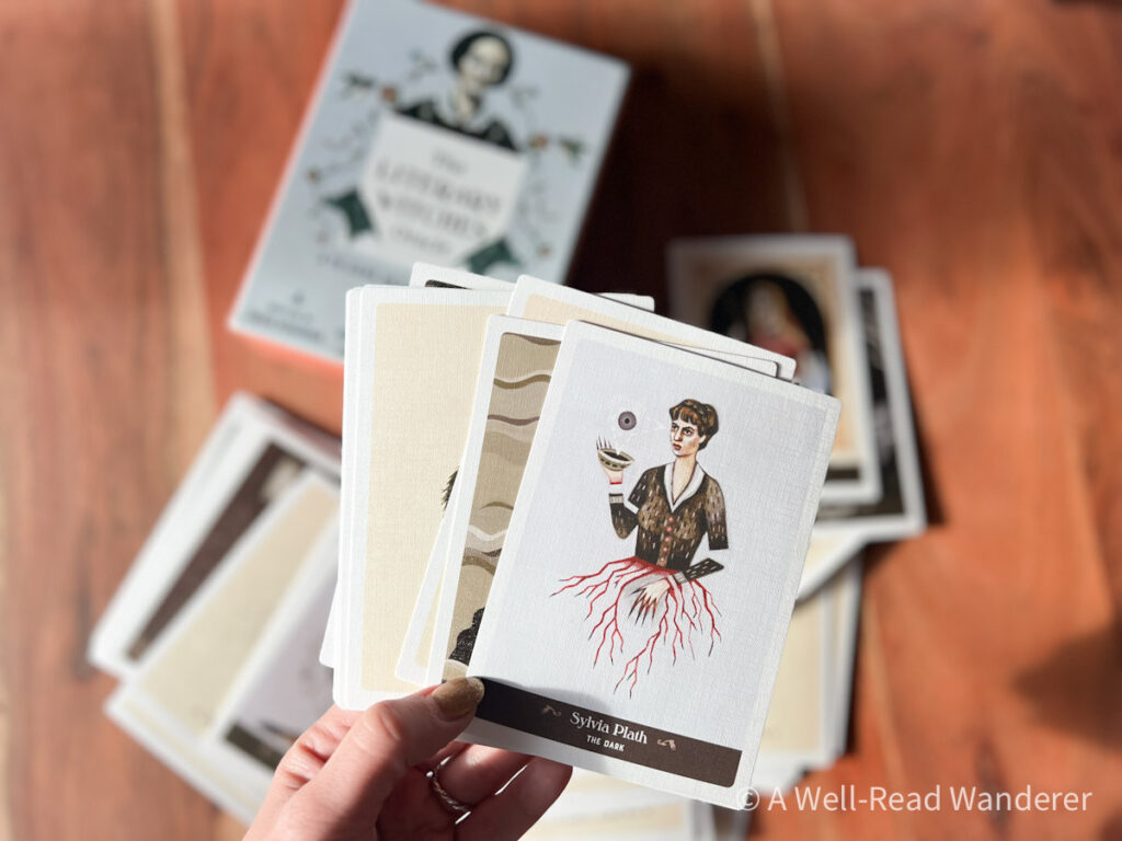 female writer tarot cards held open with the box in the background, a great bookish stocking stuffer