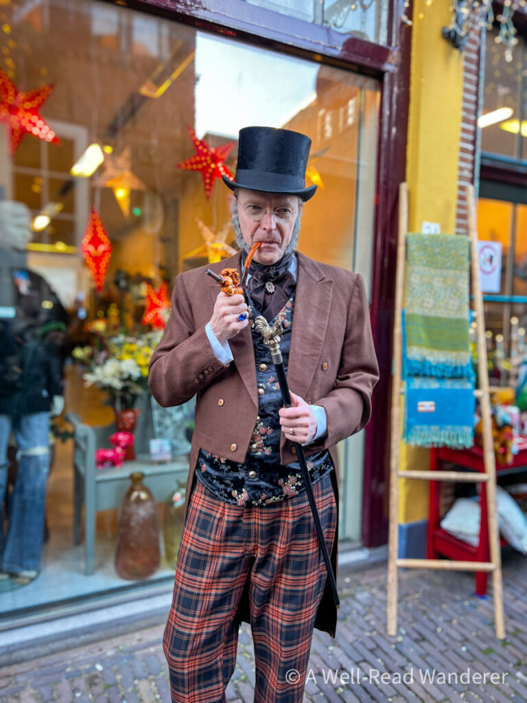 man dressed in victorian costume and top hat with pipe at dickens festival in netherlands