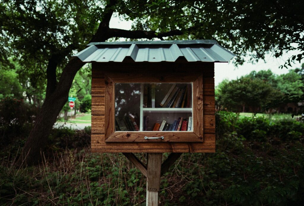 Rustic outdoor little free library surrounded by lush greenery, perfect for community sharing.
