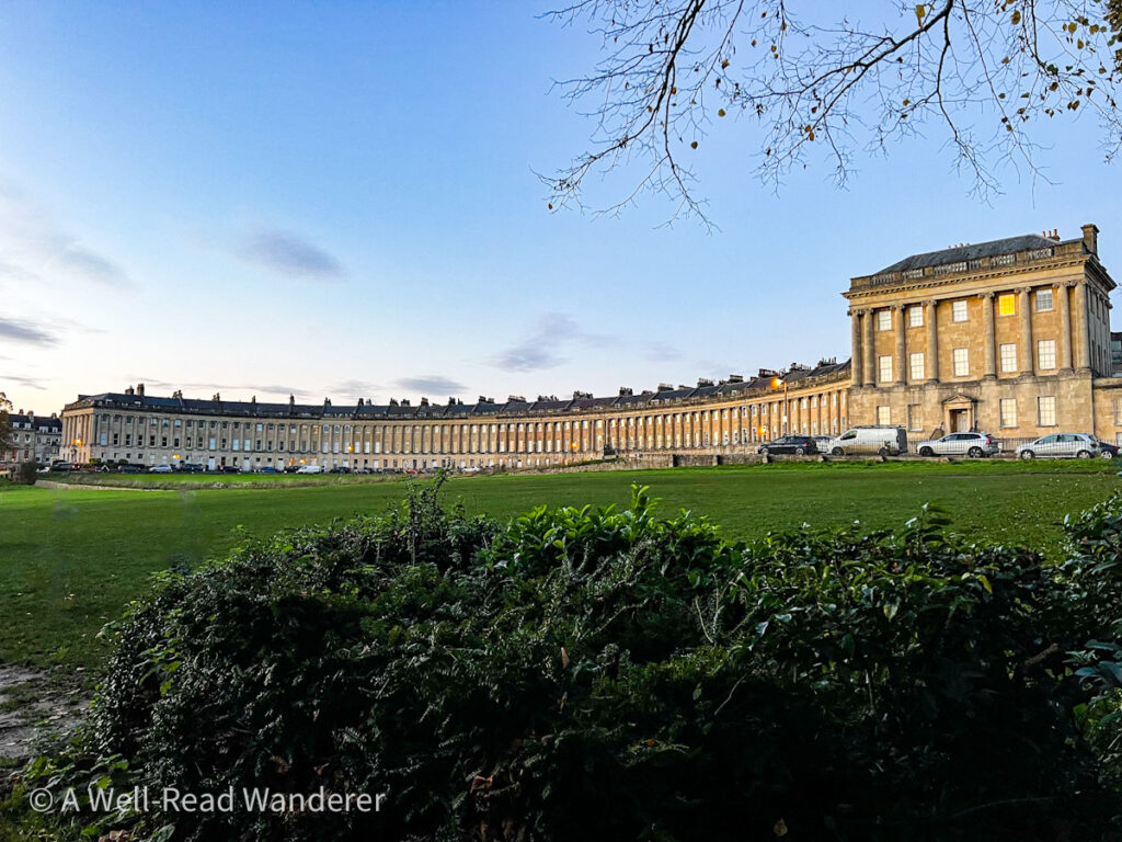 royal cresent in bath a round row of georgian townhomes in the distance with an open green space in foreground