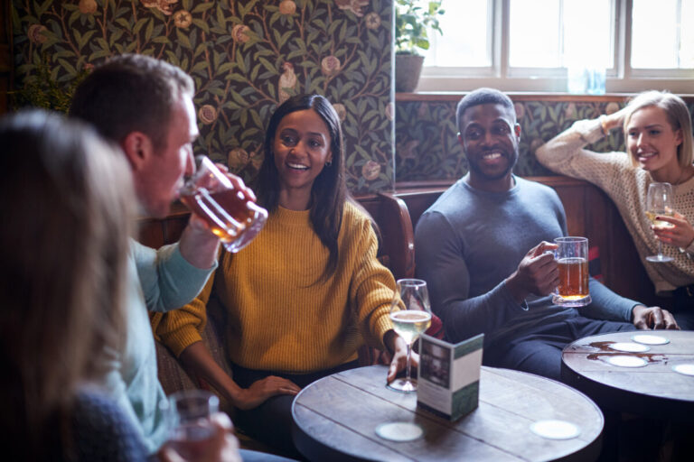 friends sitting in a classic london pub with various drinks