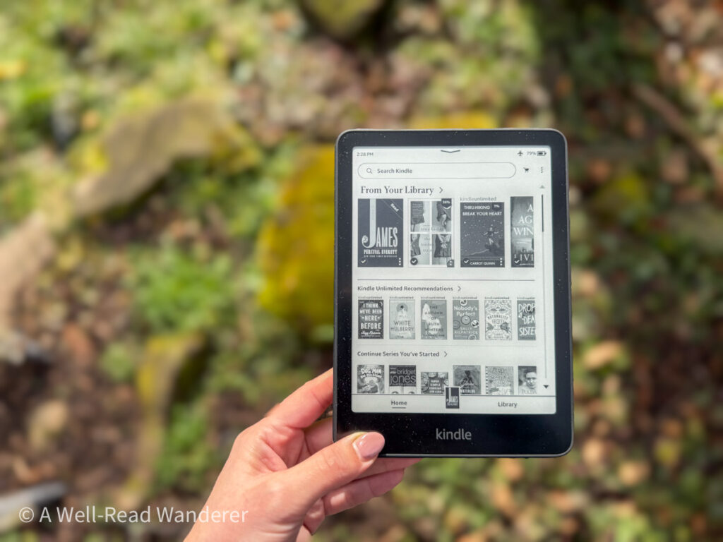 kindle paperwhite 12th generation home screen held over green grass