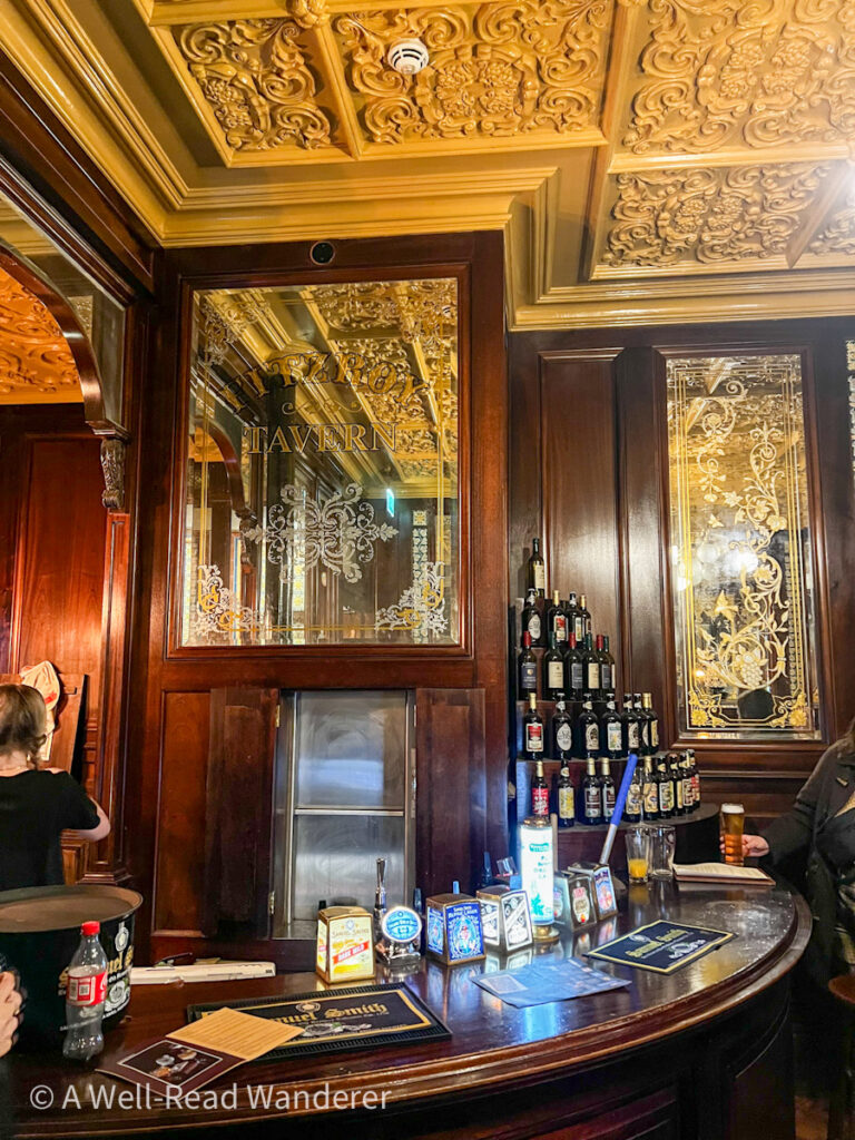 interior of the artists bar in london with decorative ceiling and historic dark wood bartop and taps