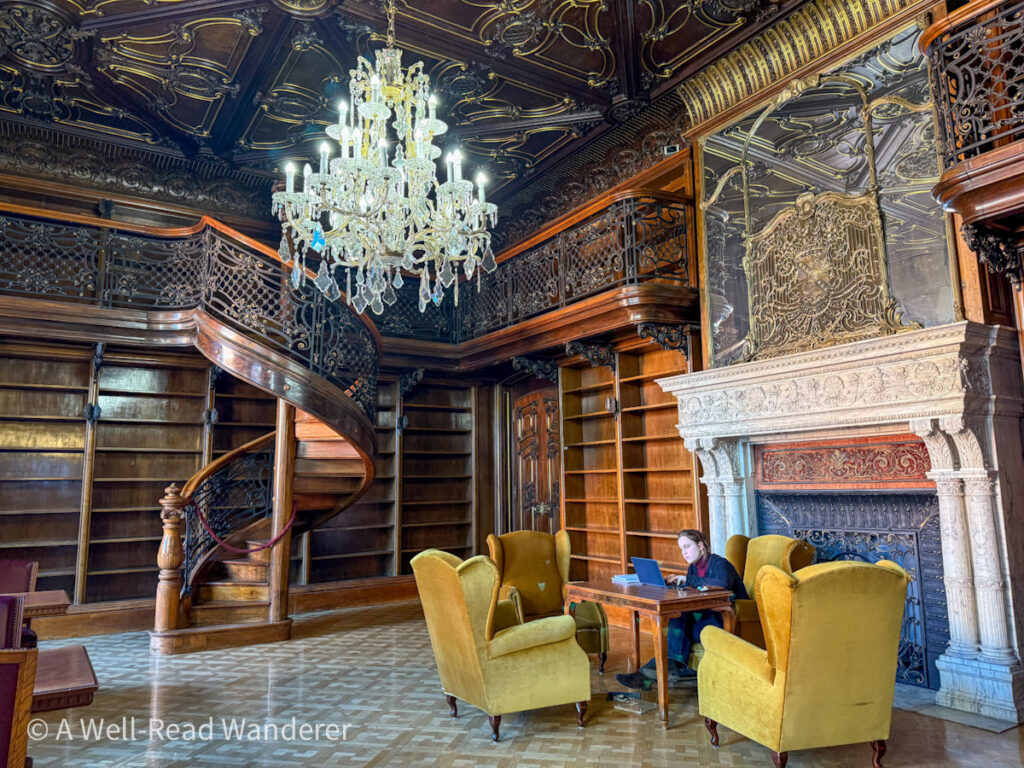 interior of metro ervin szabo library budapest a dark wood library room with spiral staircase and yellow armchairs by fireplace