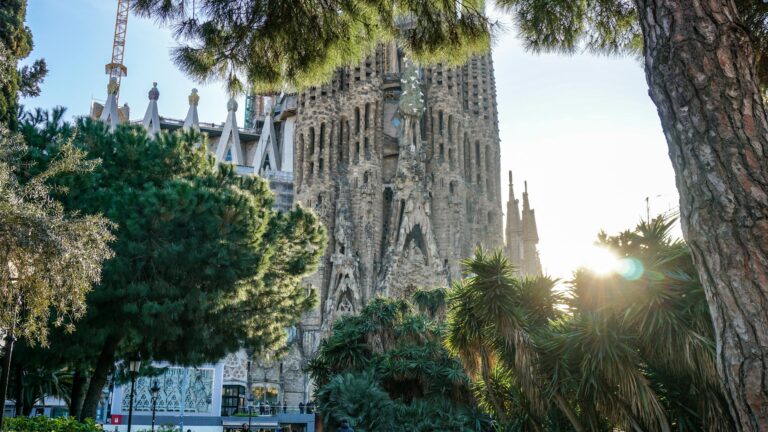 A picturesque view of Sagrada Familia with surrounding trees in Barcelona, Spain.