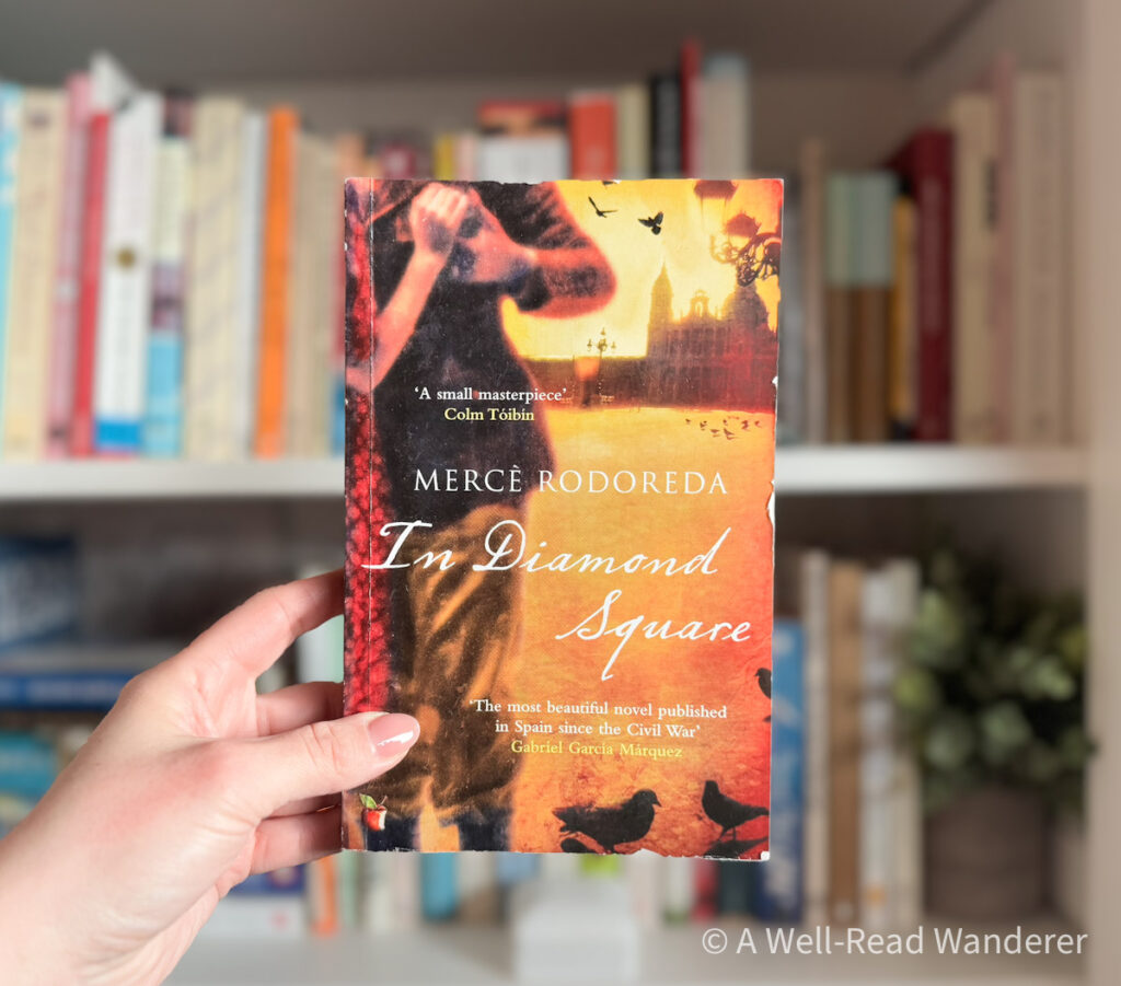 in diamond square by merce rodoreda novel set in barcelona held by manicured hand in front of bookshelf